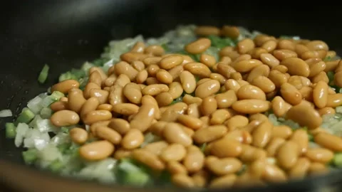 Adding canned beans and corn to chopped fresh green bell pepper, onion and 스톡 동영상 151289785