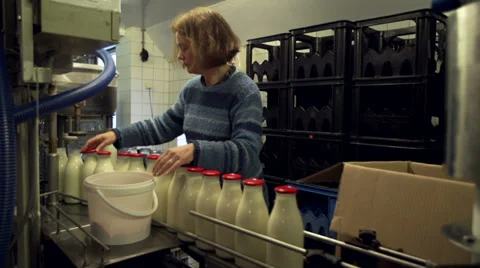 Adding caps to bottles filled with milk Stock Footage 35178762