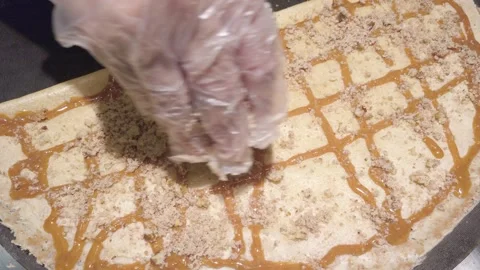 Adding caramel and nuts on crepe Stock Footage 311552468