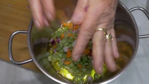 Adding Carrot Celery and Onion Soffritto Mix Into Oiled Pan, Home Kitchen Video stock 337956919