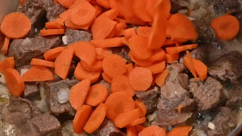 Adding carrot to meat, onion and garlic Stock Footage 221355450