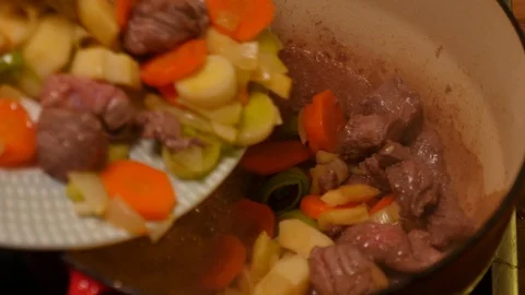 Adding casserole ingredients to a pot Stock Footage 121448957