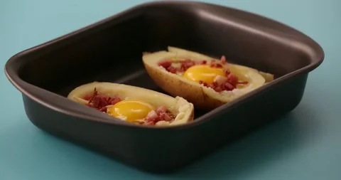 Adding cheese to bacon, eggs, and cheese in potato halves 2 Video stock 132149152