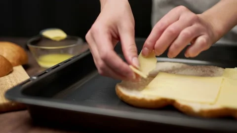 Adding cheese on bread rolls in slow motion. Stock Footage 135463221