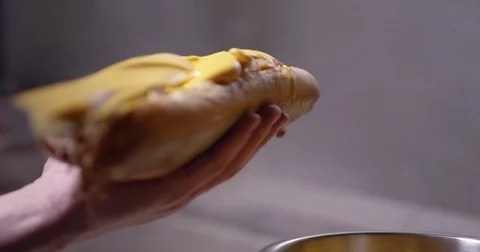 Adding cheese whiz to an authentic Philadelphia cheesesteak Stock Footage 85043297