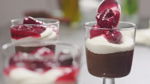 Adding cherry topping to the chocolate pudding. Stock Footage 153459217
