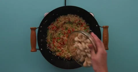 Adding chicken to rice and vegetable mixture Stock Footage 132198531
