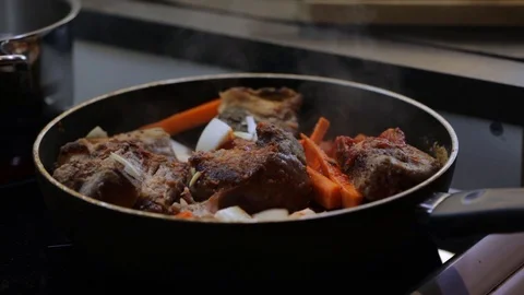 Adding chicken stock to beef ribs Stock Footage 120462806