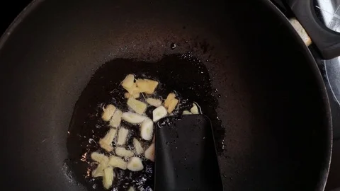 Adding chicken into wok overhead Stock Footage 98360973