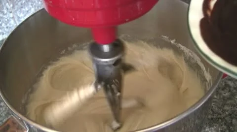 Adding chocolate to brownie mix in mixer Stock Footage 10919279