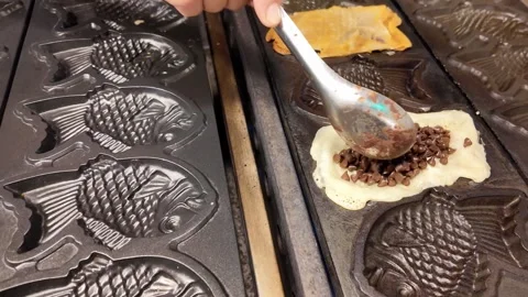 Adding chocolate filling to Taiyaki waffle, Thailand 스톡 동영상 344373359