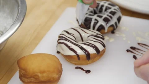 Adding chocolate icing to a prepared donut Stock-Footage 307339996