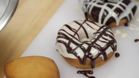 Adding chocolate icing to a prepared donut Stock-Footage 307339997