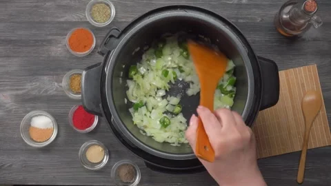 Adding chopped green chili pieces into an instant pot top view Stock Footage 311060316