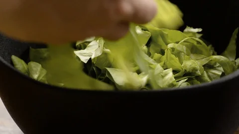Adding Chopped Lettuce to Modern Black Salad Bowl Stock Footage 116787253