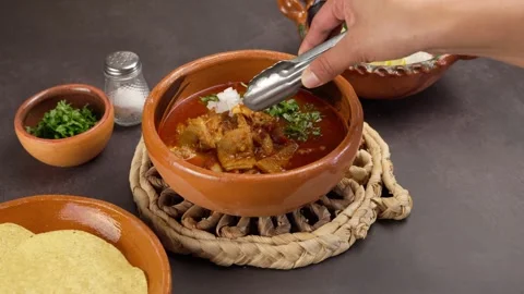 Adding chopped onion to a plate of mondongo or mole de panza Stock Footage 279206743