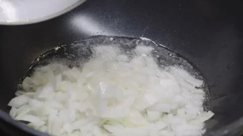 Adding Chopped Onions Into Hot Pan With Oil Vidéo 332810153
