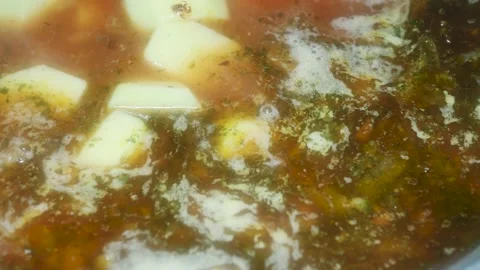 Adding chopped potatoes to red borscht with cabbage and beets, macro Vídeos de archivo 231324730