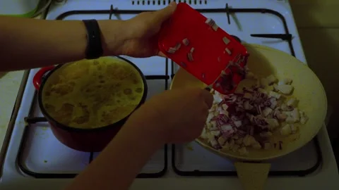 Adding Chopped Red Onion to Frying Pan During Home Cooking 库存影片 341767384