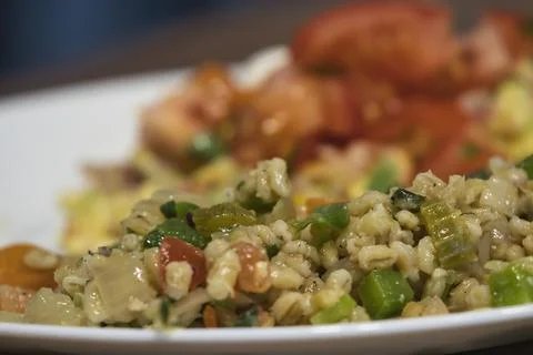 Adding chopped red tomatoes on top of an omelet Stock Photos
