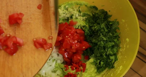 Adding chopped tomatoes, cooking guacamole Stock Footage 244422728