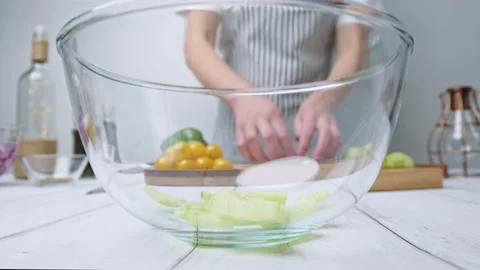 Adding chopped Tomatoes, Cucumber, Red onion, Green Bell Pepper in a Greek Salad Stock Footage 142113323