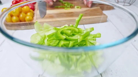 Adding chopped Tomatoes, Cucumber, Red onion, Green Bell Pepper in a Greek Salad Stock Footage 142113558