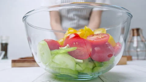 Adding chopped Tomatoes, Cucumber, Red onion, Green Bell Pepper in a Greek Salad Stock Footage 142114757