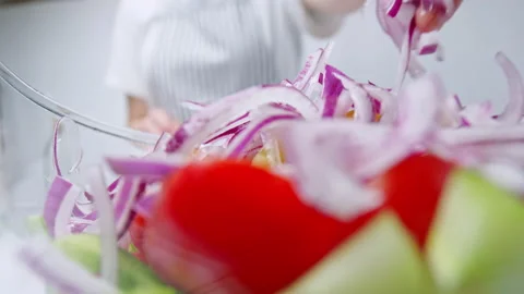 Adding chopped Tomatoes, Cucumber, Red onion, Green Bell Pepper in a Greek Salad Stock Footage 142114961