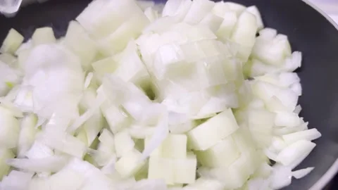 Adding chopped white onion in frying pan. Close up. 스톡 동영상 168435877