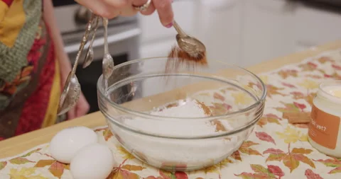 Adding cinnamon spice powder to mixing bowl dry mix Stock Footage 249313057