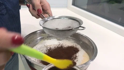 Adding Cocoa to a Bowl with Flour and Eggs - Making a Pie Stock Footage 123539531