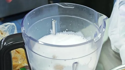 Adding coconut palm sugar into a blender with milk or coconut milk. Vídeo Stock 346536879