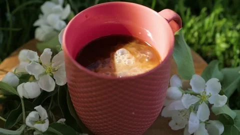 Adding coffee cream to black coffee. Slowly pouring cream into a cup of black Stock-Footage 148659380
