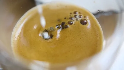 Adding coffee creamer into black coffee Stock Footage 236935078