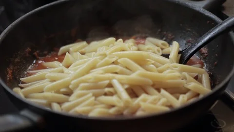 Adding cooked pasta closeup Stock Footage 97411216