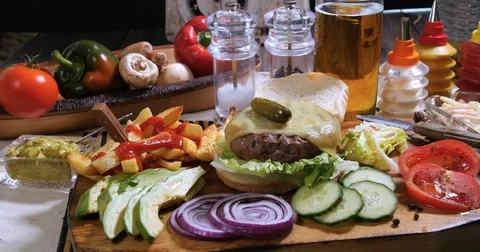 Adding cornichons over a delicious cheesburger Stock Footage 73737247