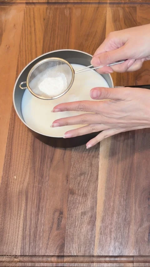 Adding Cornstarch to Milk and Mixing in Saucepan Vertical Video Видео 334802479