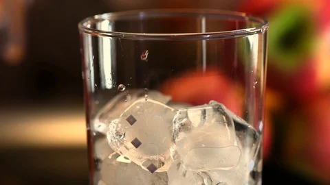 Adding couple ice cubes in cocktail glass with melted ice. Stock Footage 114498518