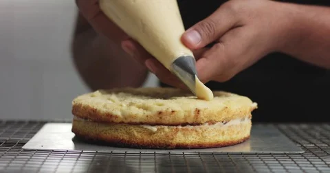 Adding cream and fruit to cake Stock Footage 82993704