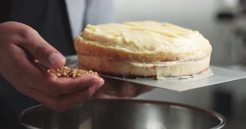 Adding cream and fruit to cake Stock Footage 82993760