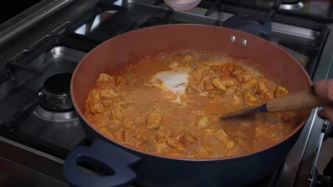 Adding cream to cooking chicken Stock Footage 321930453