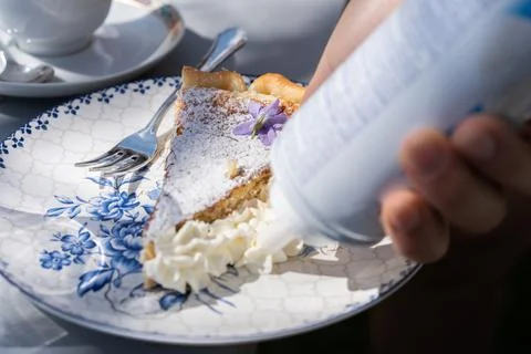 Adding cream to fresh self made easter pie. Cake with flower and cream decora Stock Photos