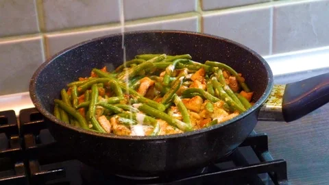 Adding cream into frying vegetables and chicken white meat in the pan Stock Footage 116203338