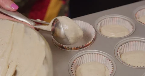 Adding cupcake mix into tray and wrapper with scoop Video stock 249352570