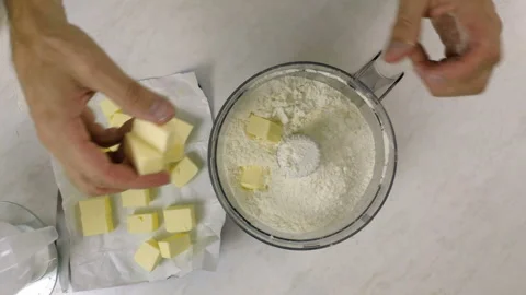 Adding diced butter into food processor cup with flour Stock Footage 97969470