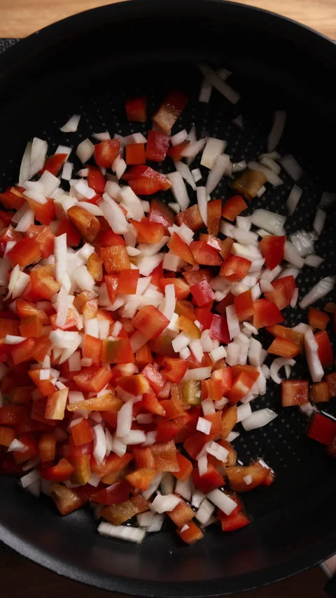 Adding Diced Onion and Red Bell Pepper to Hot Frying Pan Vertical Top View Vídeos de archivo 336568003