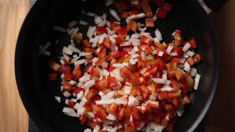 Adding Diced Onion and Red Bell Pepper to Frying Pan Top View Vidéo 336568020