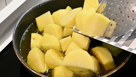 Adding diced potatoes to the pan with oil Stock Footage 221355739
