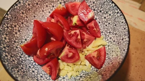 Adding Diced Tomatoes and Chopped Garlic to a Bowl Vídeos de archivo 344669523